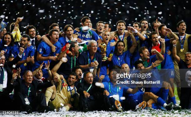 The Italian players and coaching staff celebrate with the World Cup trophy following their victory in a penalty shootout at the end of the FIFA World...
