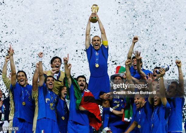 The Italian players celebrate as Fabio Cannavaro of Italy lifts the World Cup trophy aloft following victory in a penalty shootout at the end of the...