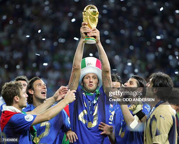 Italian defender Marco Materazzi holds up the 2006 World Cup trophy after Italy won their final football match against France at Berlin?s Olympic...
