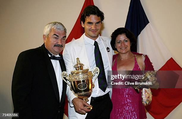 Roger Federer of Switzerland poses with his trophy and parents Lynettee and Robert at the Wimbledon Winners' Dinner at the Savoy Hotel on July 9,...