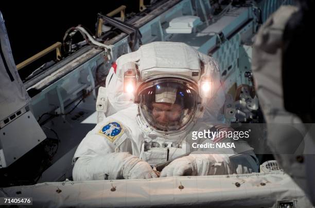 In this handout photo provided by NASA, astronaut Piers J. Sellers, STS-121 mission specialist, works on a section of the International Space Station...