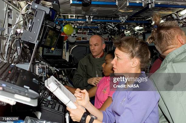 In this handout photo provided by NASA, astronaut Lisa M. Nowak , STS-121 mission specialist, refers to a procedures checklist as astronaut Stephanie...