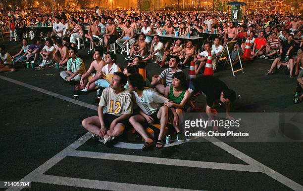 Football fans watch the World Cup final between Italy and France on an outdoor screen on July 10, 2006 in Chongqing Municipality, China. Italy went...