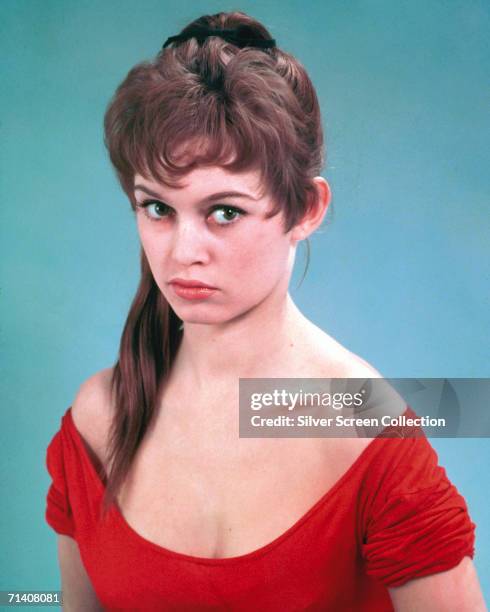 French actress Brigitte Bardot wearing a low-necked red dress, circa 1955.