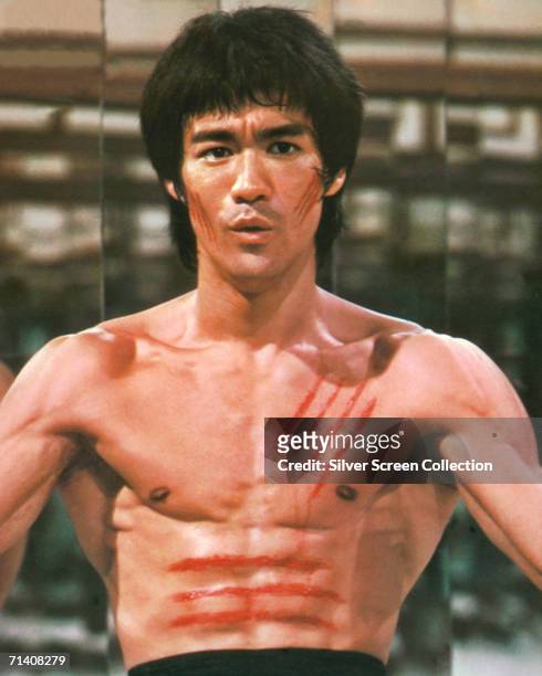 American martial arts star Bruce Lee stars in 'Enter the Dragon', directed by Robert Clouse, 1973. Bloody scratches cover his chest and face.