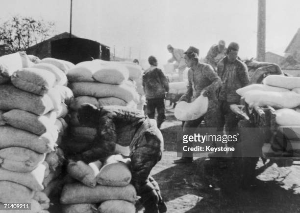 Communist troops of the Chinese Red Army pile up sandbags during the assault on Shanghai at the end of the Chinese Civil War, 21st May 1949.