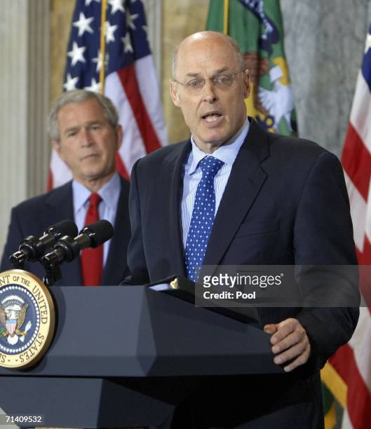 Investment banker Henry Paulson speaks after being sworn in by Chief Justice John Roberts as U.S. President George W. Bush looks on during a ceremony...
