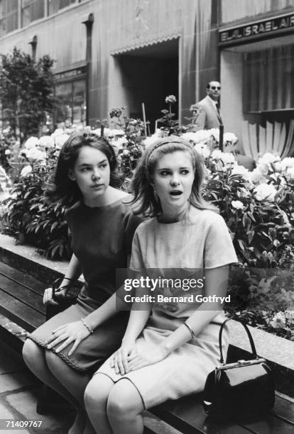 The two daughters of former Vice President Richard Nixon, Julie and Tricia, sit on a bench and gawk outside the El Al office, Rockefeller Center,...