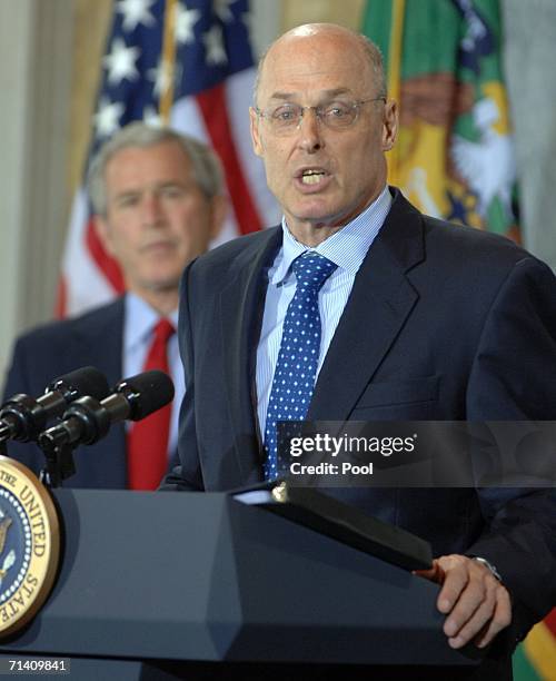 Investment banker Henry Paulson speaks after being sworn in by Chief Justice John Roberts as U.S. President George W. Bush looks on during a ceremony...