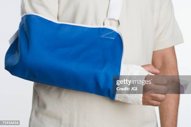 close up of man's arm in sling - cabestrillo de brazo fotografías e imágenes de stock