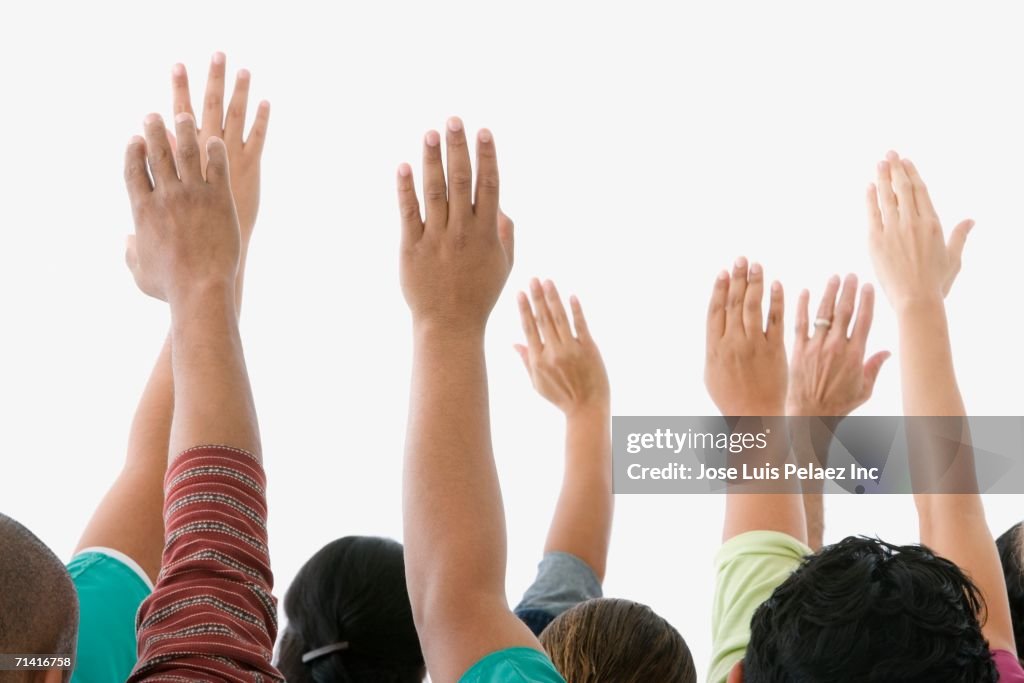 Studio shot of people raising their hands