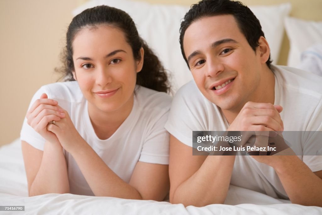 Hispanic couple lying on the bed