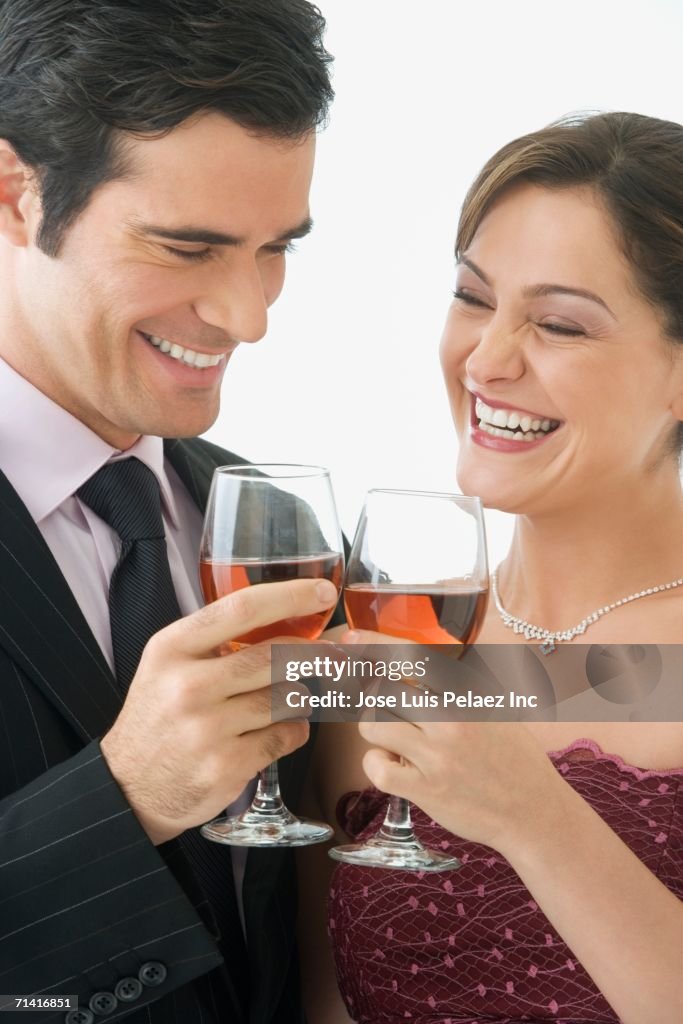 Studio shot of couple toasting with wine glasses