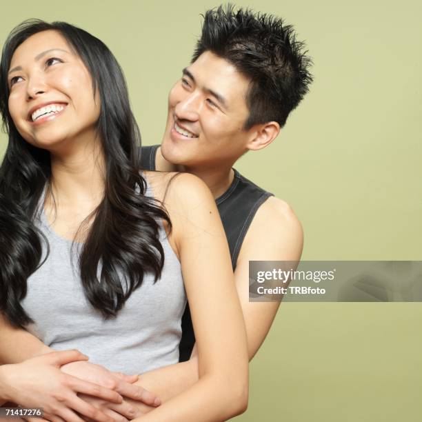 studio shot of young asian couple hugging - korean language stock pictures, royalty-free photos & images