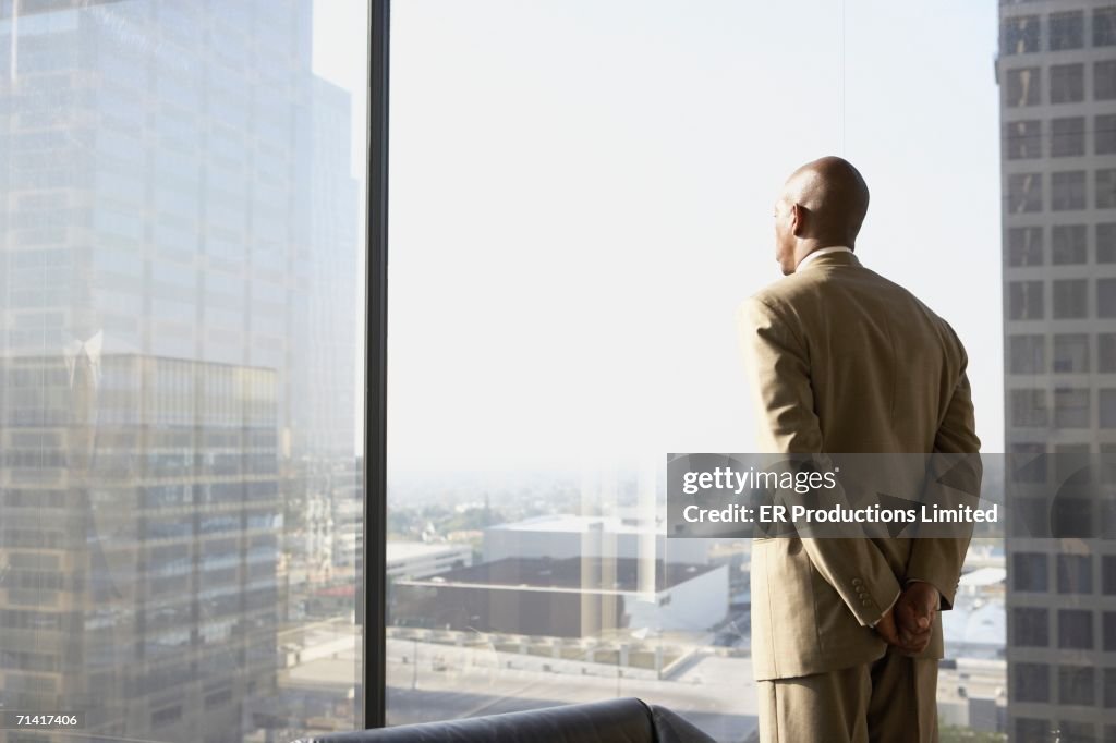 African businessman looking out a window