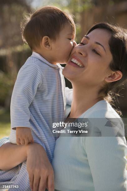 hispanic baby kissing mother on the cheek - cheek texas stock pictures, royalty-free photos & images