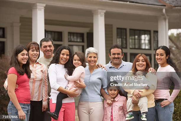 large hispanic family standing in front of house - multi generation family portrait stock pictures, royalty-free photos & images