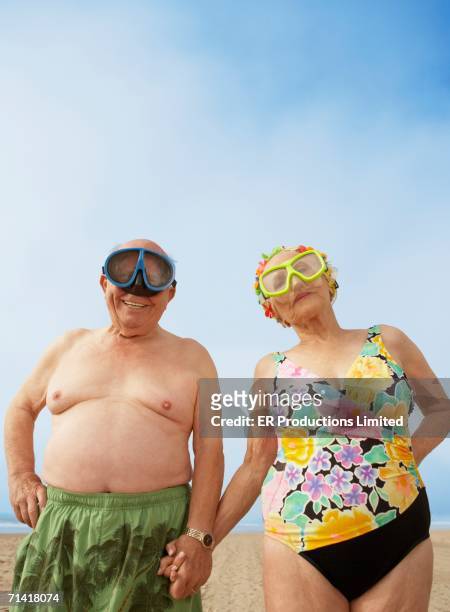 senior couple wearing goggles at the beach - fun holidays beach stock-fotos und bilder