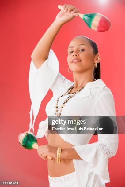 studio shot of a female dominican teenager with maracas - maracas stockfoto's en -beelden