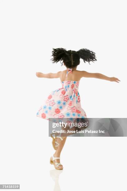 studio shot of young african girl twirling - turning back stock pictures, royalty-free photos & images