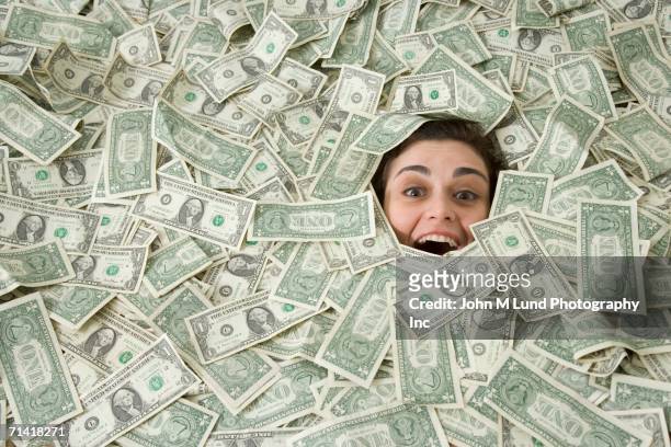 woman's face peeking out of a pile of money - large group of objects stock pictures, royalty-free photos & images