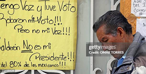 Una persona pasa junto a un cartel alusivo a posibles irregularidades en las elecciones presidenciales del pasado 02 de julio, en las afueras del...