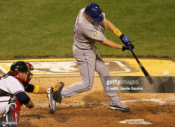 American League All-Star Michael Young of the Texas Rangers hits a two-run triple to take the lead against the National League All-Star team during...