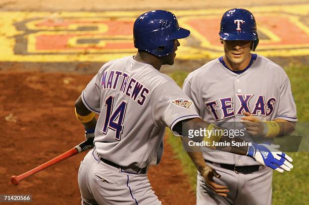American League All-Star Michael Young of the Texas Rangers is greeted by teammate Gary Matthews Jr. After Young hits a game winning two-run triple...