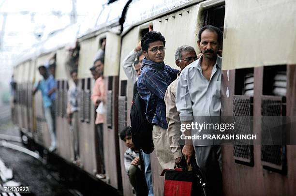 People travel on the local train as service resumed in the morning after the series of train bomb blasts in Mumbai,12 July 2006. The death toll from...