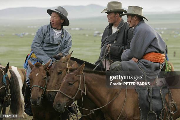 Mongolian men watch a gruelling 30km horse race during the annual Naadam Festival at Khui Doloon Khudag 40km from the capital Ulan Bator, 12 July...