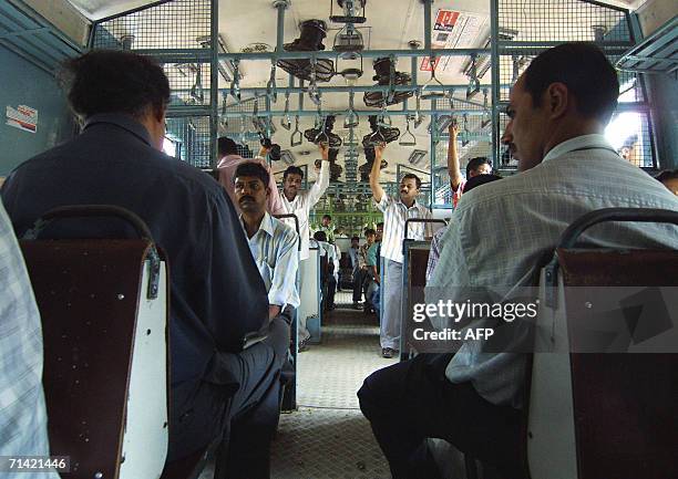 Commuters travel in a local train in the early hours of the morning in Mumbai, 12 July 2006. The death toll from a wave of co-ordinated blasts on...