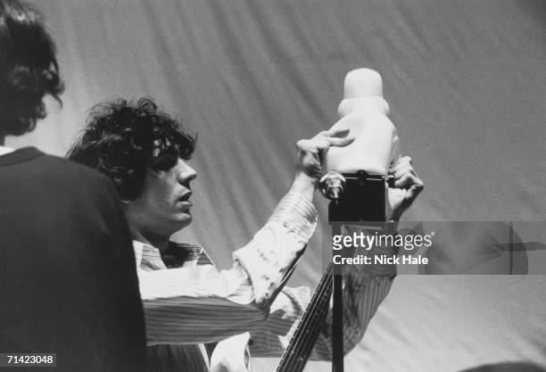 Syd Barrett of British psychedelic rock group Pink Floyd adjusts a rubber duck during rehearsals for the group's show 'Games for May' at the Queen...