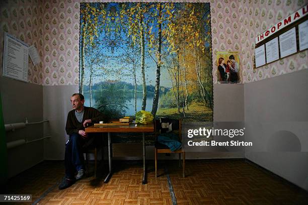 Patient sits alone in the entertainment room of the Aids wing of Poltava Psychiatric Hospital on August 15, 2005 in Poltava, Ukraine. There is no...