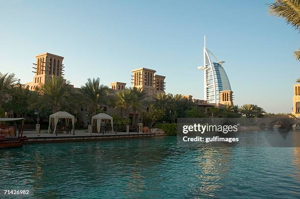 view of madinat jumeirah seen from the lake - madinat jumeirah hotel stock pictures, royalty-free photos & images