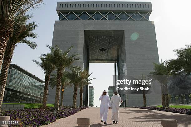 arab men walks outside the building - dubai difc stock pictures, royalty-free photos & images