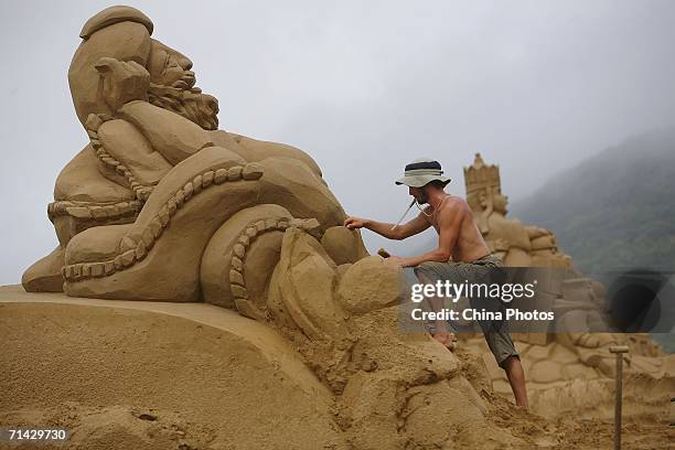 Sand artist adds finishing touches to a sand sculpture on Nansha Beach, on July 12, 2006 in Zhujiajian Island, China. The 8th Zhoushan International...