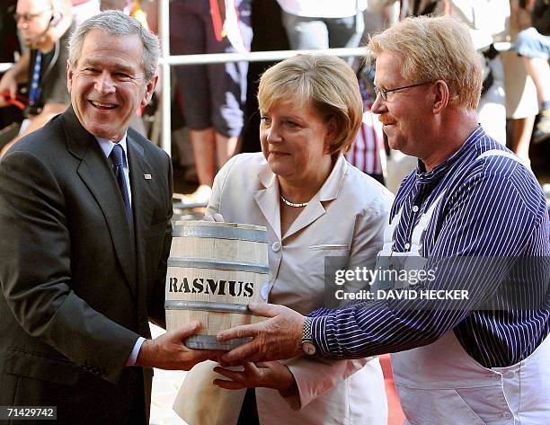 President George W. Bush receives a barrel of hering from a lokal as he and German Chancellor Angela Merkel and arrive at the market place of...