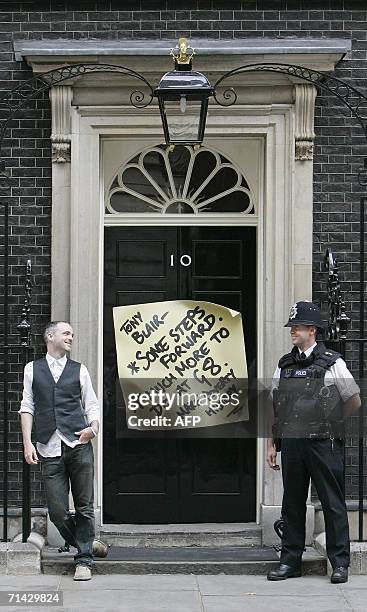 United Kingdom: Fran Healy, lead-singer of Scottish rock band, Travis, sticks a giant paper note to the front door of 10 Downing Street in London, 13...
