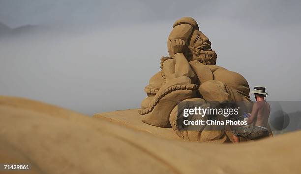 Sand artist adds finishing touches to a sand sculpture on the Nansha Beach on July 12, 2006 in Zhujiajian Island, China. The 8th Zhoushan...