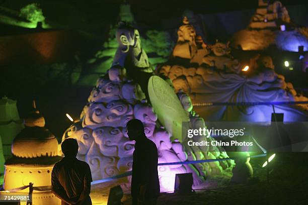 Visitors admire sand sculptures on the Nansha Beach on July 11, 2006 in Zhujiajian Island, China. The 8th Zhoushan International Sand Sculpture...