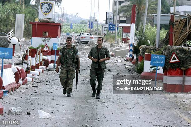 Lebanese soldiers walk amidst the rubble at their post after Israeli warplanes targeted a bridge nearby on the Awali River, north of the southern...