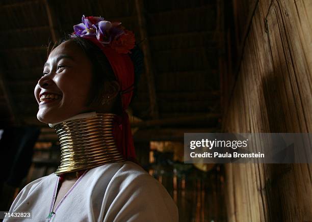 Mah Su,1 9, a Long Neck Padaung hill tribe woman smiles as she poses inside her home July 13, 2006 in Chiang Dao, Thailand. All the Long Neck...