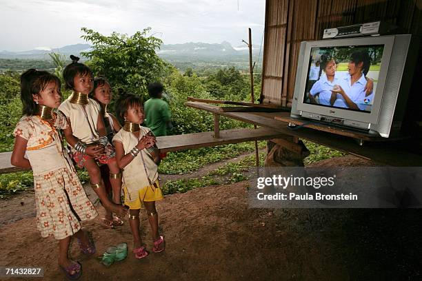 Young Long Neck Padaung hill tribe girls watch television in a small village where 30 familes live July 13, 2006 in Chiang Dao, Thailand. All the...