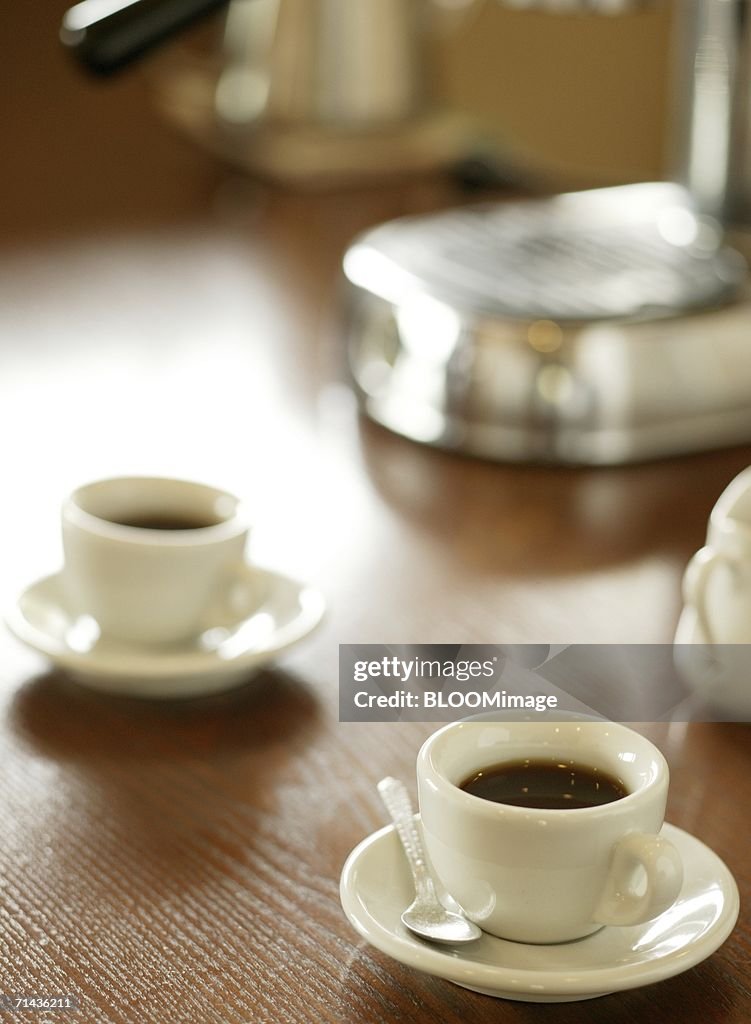 Two cups of coffee and espresso machine on table