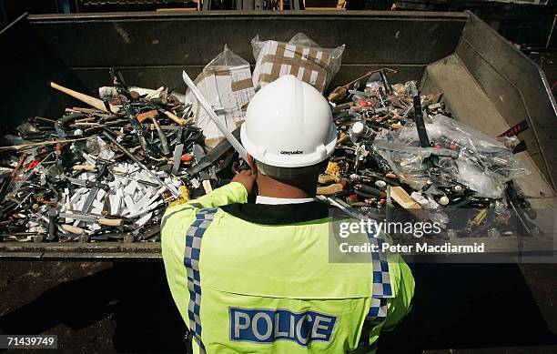 Police Constable Mike Ellis checks knives before crushing on July 14, 2006 in Hitchin, England. Police say that 100,000 knives and other weapons were...