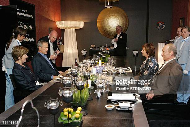 Russian President Vladimir Putin , his wife Ludmila , US President George W. Bush and his wife Laura attend a dinner, 14 July 2006, in Strelna...