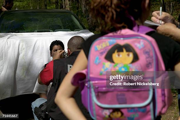 Armed police from Maryland's Prince George's County Anti-Gang Unit question and search suspected gang members on April 19, 2006 in Langley Park,...