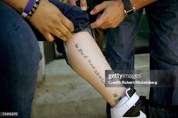 Armed police from Maryland's Prince George's County Anti-Gang Unit question and search a known female MS-13 gang member on April 19, 2006 in Langley...