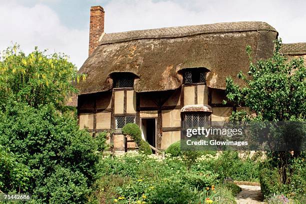 tourists taking a tour of anne hathway's cottage, stratford, england - anne hathway stockfoto's en -beelden