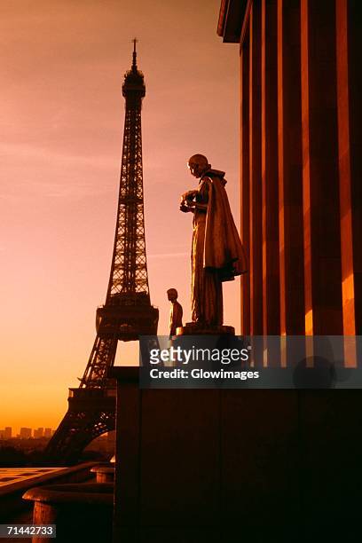 eiffel tower seen at the back of a palace statue at sunset, paris, france - expensive statue stockfoto's en -beelden